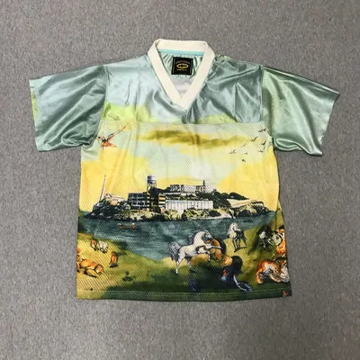 A mesh football shirt printed edge to edge with a painted landscape of an island, horses and birds
