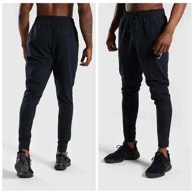 Two photographs of black tapered joggers worn with black trainers, one from the back and one from the front